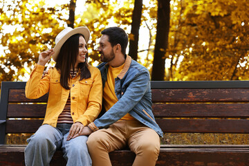 Beautiful couple spending time together in park on autumn day