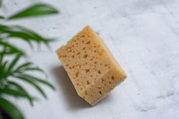 Natural coconut sponge on a marble table. Dishwashing accessory made of natural materials.