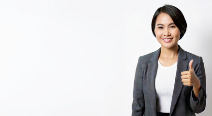 Asian businesswoman is giving a thumbs up against a white background.