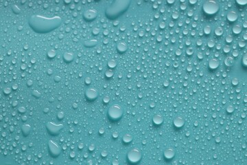 Water drops on turquoise background, above view