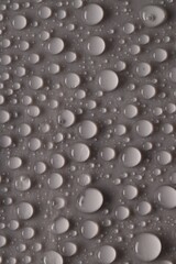 Water drops on gray background, top view