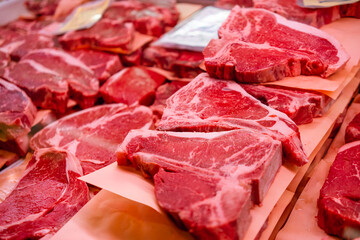 Various cuts of beef sit on display at a butcher's counter