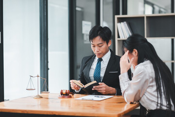 Two business professionals engaged in a serious discussion in a modern office setting, focusing on legal consultation.