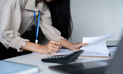 Determined Business Woman Working Diligently at Office Desk with Documents and Calculator