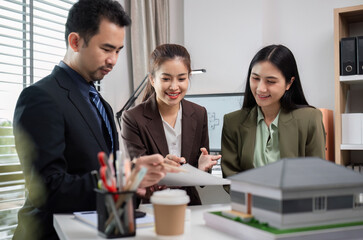 Business Team Discussing Real Estate Project in Modern Office with Architectural Model and Documents