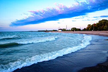 dramatic cloud over expansive beach with waves room for text shot on kew beach in toronto's beaches neighbourhood ideal as background