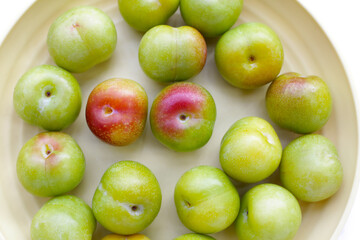 Fresh green plum on white background