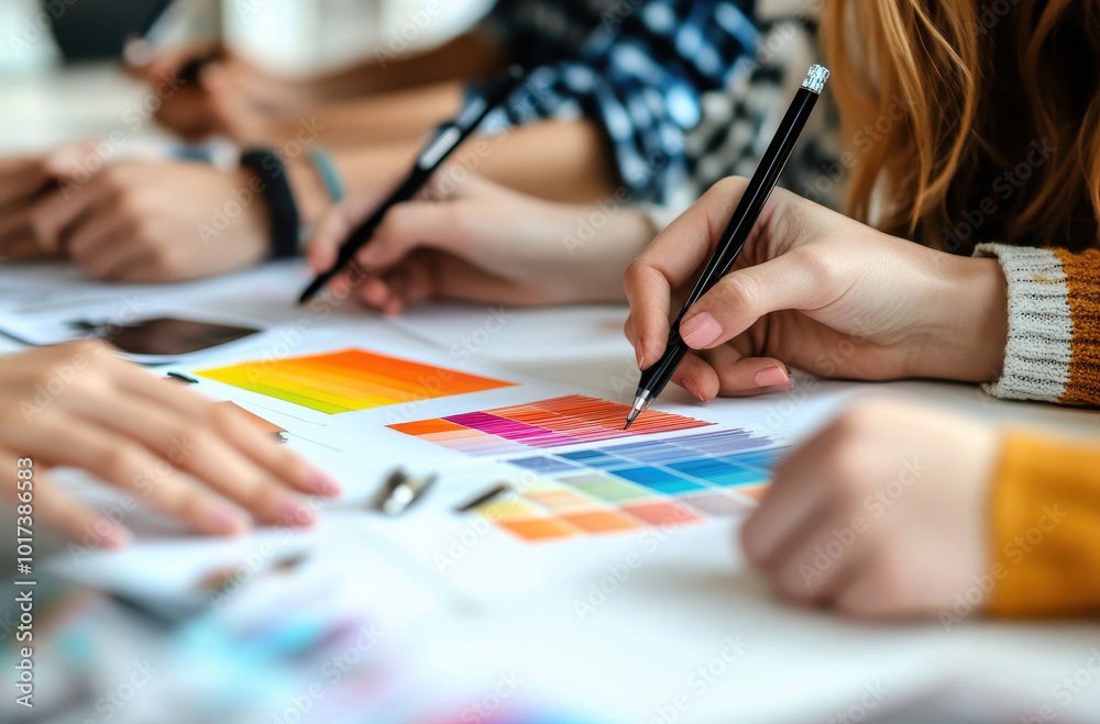 Fototapete a group of designers working together on a graphic design project, using color swatches and drawing 
