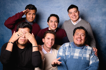 Obraz premium Group of 6 men in sweater on blue background in 90's yearbook style. Posing comically as a tv show