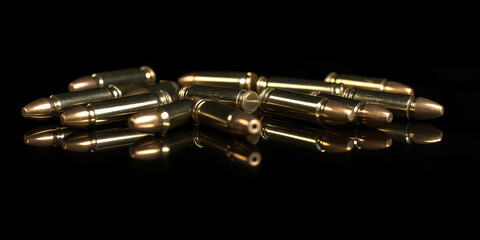 Naklejka premium 9mm bullets laying on a black reflective surface