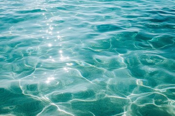 Obraz premium Turquoise ocean water with sun reflection, ripples and waves.