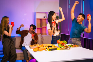 Four Asian friends, two men and two women, celebrate in an office party. They enjoy a fun-filled night with food, drinks, and laughter, bonding over teamwork and friendship.