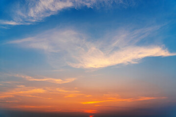 Cirrus evening clouds backlit by the sun, sky view.