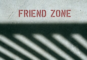 Cement floor with red text FRIEND ZONE - when someone want to have a more intimate, romantic, or...