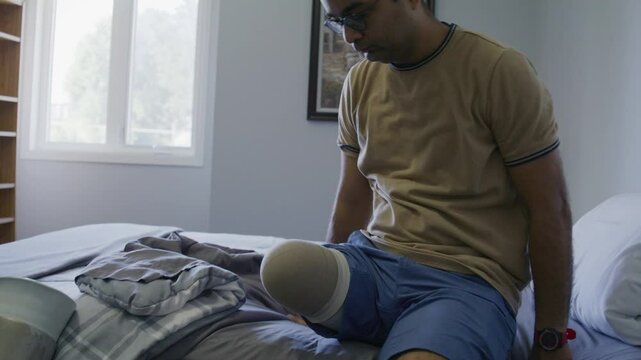 Amputee getting into bed without leg