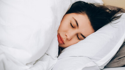 Early morning. Sleeping woman. Exhausted day. Tired female closed eyes lying in soft white bed on pillow under blanket light bedroom.