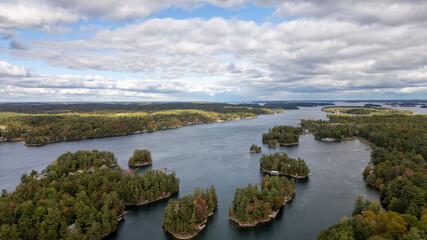 Fototapeta premium Stunning aerial views of the 1000 Islands region along the United States and Canada border, showcasing a mesmerizing landscape of lush green islands scattered across the blue waters of the St. Lawrenc