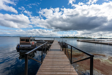 Obraz premium Panoramic aerial view of the Thousand Islands along the U.S.-Canada border, showcasing countless green islands with boat docks nestled along shimmering waters under a clear blue sky.