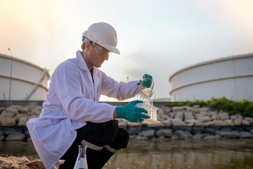 Scientist analysis professional wearing glasses and safety glove under working analysis water quality by get waste water to check water case in laboratory is environment pollution problem concept.