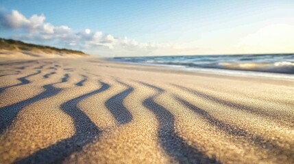 Naklejka premium Calm Waves and Gentle Sand Patterns at Sunset