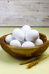Raw Eggs from white leghorn chicken on wooden bowl. Selective focus with isolated background and...