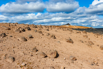 Amazing lava field in the highlands of Iceland near Myvatn, black old lava flows and volcanic rocks, mountains in the background