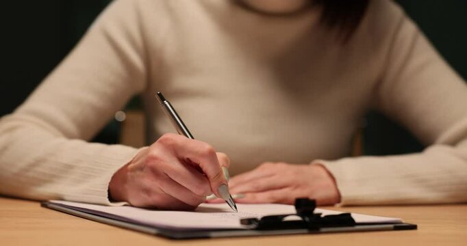 Woman manager writing a business document late at night in the office