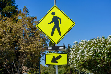 Pedestrian crossing sign with flashing lights. Crosswalk beacon provides advance notice of...