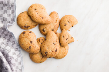 Biscotti frollini con gocce di cioccolato. Chocolate cookies on kitchen table. Top view.