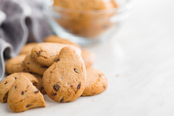 Biscotti frollini con gocce di cioccolato. Chocolate cookies on kitchen table.