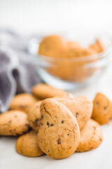 Biscotti frollini con gocce di cioccolato. Chocolate cookies on kitchen table.