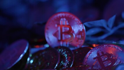 Reveal of Bitcoin coin, stands out among others, illuminated in red against deep blue background
