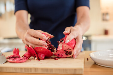 Breaking a part a pomegranate with seeds
