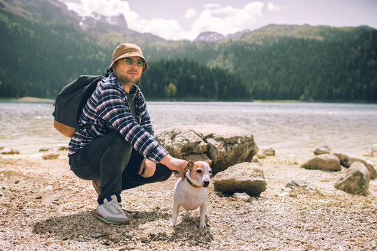 Hiker young man traveler with backpack with his dog