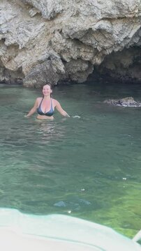 Vacation. Young woman swimming and bathing at sea rock lagoon.