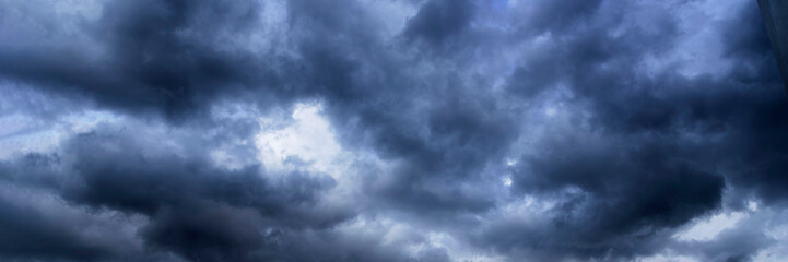 Banner Dramatic dark storm clouds black sky background. Dark thunderstorm clouds rainny season. Panorama Meteorology danger windstorm disasters climate. Dark cloudscape storm cloud with copy space.