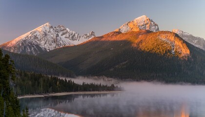 Obraz premium a tranquil mountain lake at dawn, with mirror-like reflections of snow-capped peaks