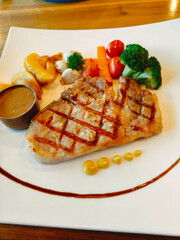 Grilled pork steak filet mignon with potato and sauce in plate