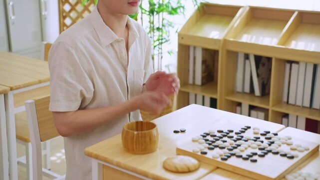 Asian young men playing board game Go during competition in community.
