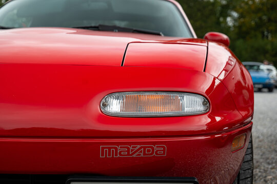 6-10-2024 Zurich, Switzerland. 1990s NA Mazda MX-5 closed headlight unit and written logo. Close up shot, shallow depth of field, no people