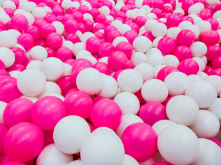 pink and white plastic balls in a playground area