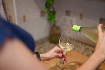 a girl pouring sparkling white wine into a wine glass

