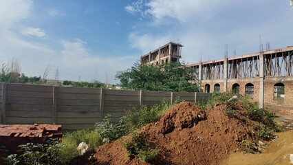 Obraz premium Under Construction Building with Brickwork and Overgrown Vegetation in a Rural Setting