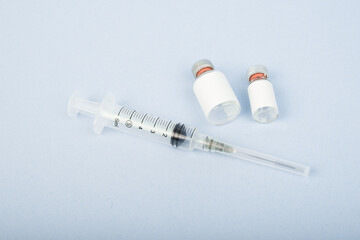Top view Vaccine bottle with syringe isolated on blue bright backround and copy space