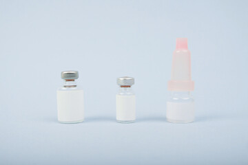 Transparent glass bottles for vaccine injections mockup isolated on blue bright background. Can be use for medicine, cosmetic and other. Ready for your design