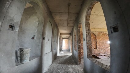 Obraz premium Interior view of an unfinished brick building featuring arched windows, highlighting ongoing construction work