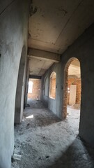 Obraz premium Interior view of an unfinished brick building featuring arched windows, highlighting ongoing construction work