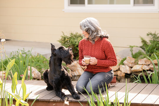Woman and dog looking at each other on bridge