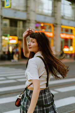 Young woman walking on city street during summer.