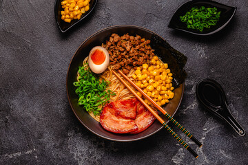 A bowl of ramen with noodles, meat and green onions.